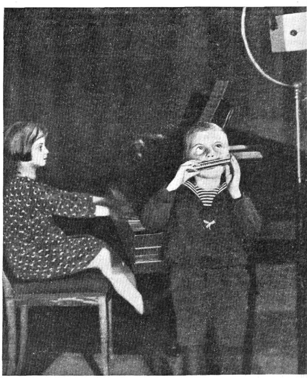 Niños tocando piano y armónica ante el micrófono, 1933